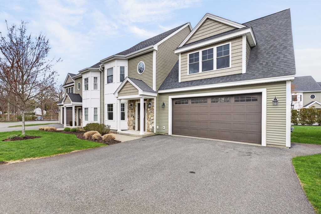 129 Acton Street, Unit 16 Maynard, MA 01754 - Photo 41 of 41 a front view of a house with a yard and garage