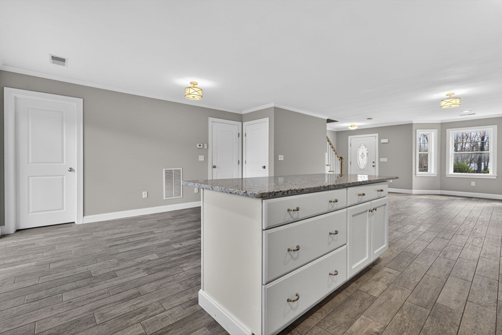 129 Acton Street, Unit 16 Maynard, MA 01754 - Photo 8 of 41 a kitchen with granite countertop white cabinets and wooden floor