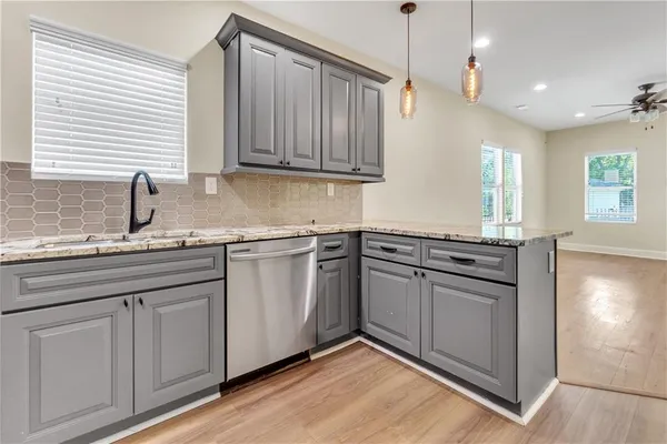 a kitchen with granite countertop cabinets stainless steel appliances a sink and a window