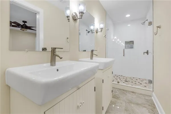 a bathroom with a sink a toilet a mirror and shower