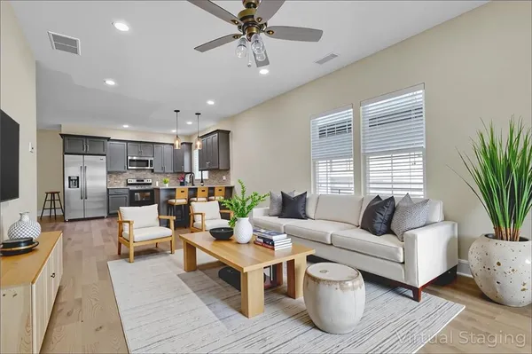 a living room with furniture kitchen view and a window