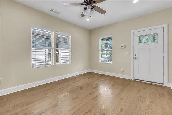 a view of an empty room with a window and wooden floor