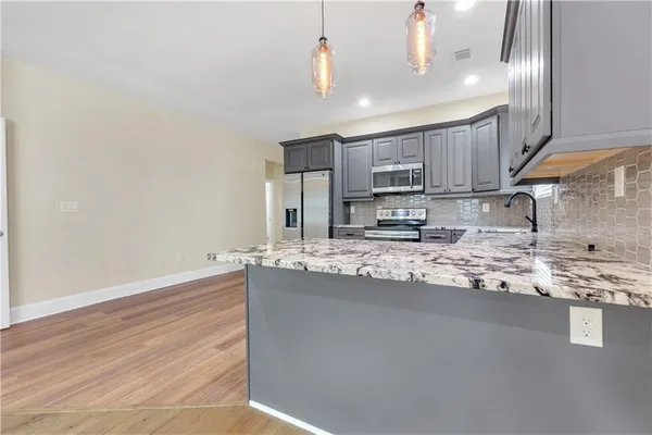 a kitchen with stainless steel appliances granite countertop a sink a stove and cabinets
