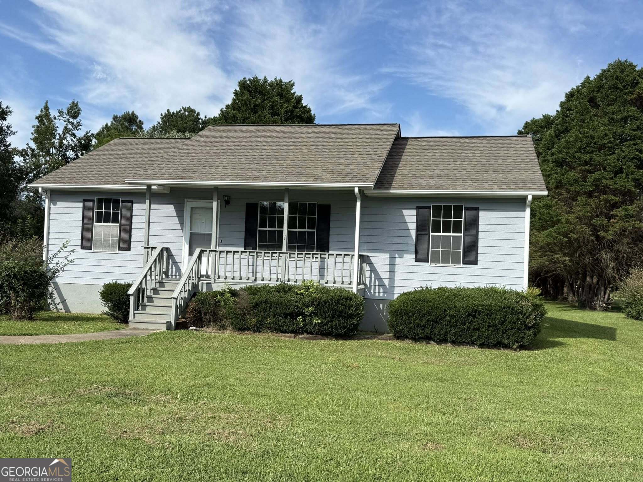a front view of a house with a garden