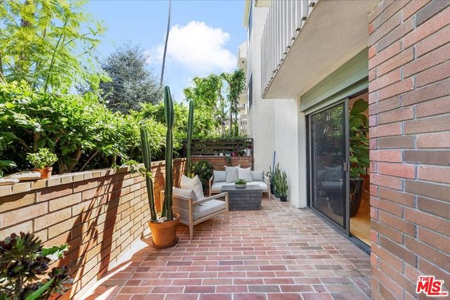 a view of a balcony with chairs and a potted plant