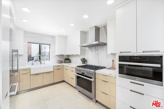 a kitchen with stainless steel appliances granite countertop a stove and a refrigerator