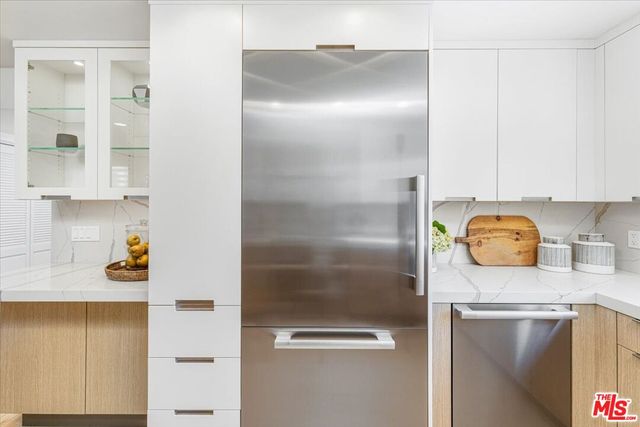 a bathroom with a granite countertop sink and a refrigerator