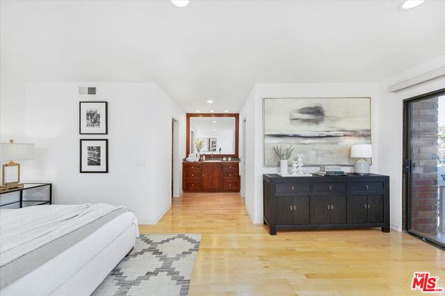 a spacious bedroom with a bed and cabinet