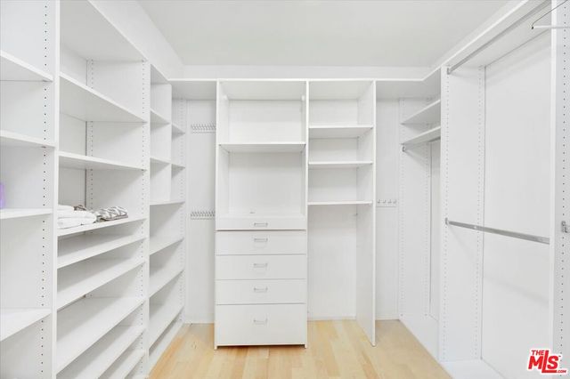 a view of walk in closet with empty racks