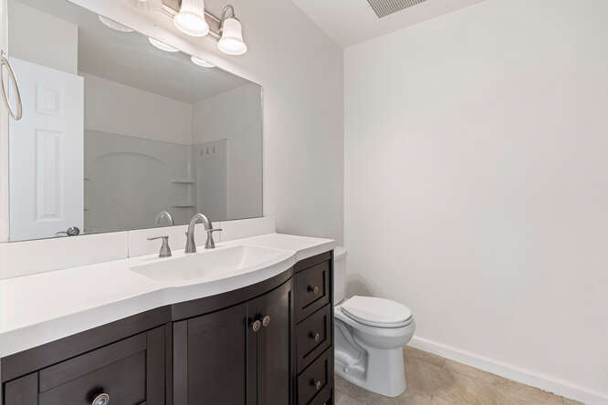 79-7199 Mamalahoa Highway, Unit 110 Holualoa, HI 96725 - Photo 17 of 26 a bathroom with a granite countertop sink a toilet and a mirror