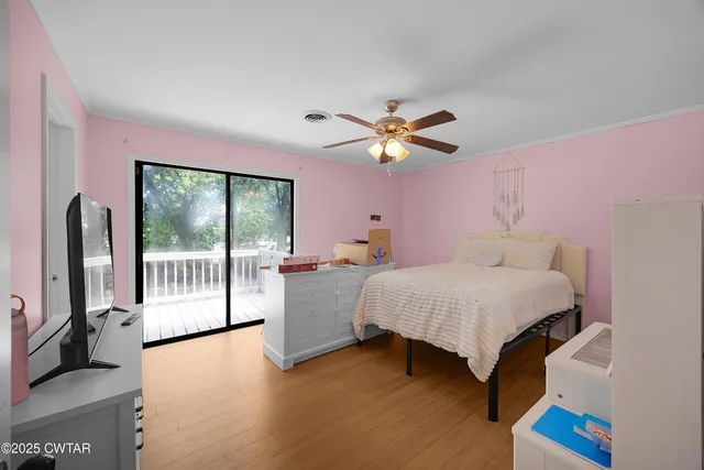 a bedroom with a bed and a large window with the outer view