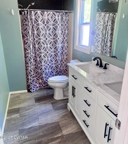 a bathroom with a granite countertop toilet a sink and a shower