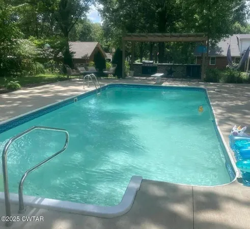 a view of a backyard with swimming pool