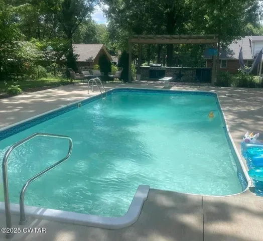 a view of a backyard with swimming pool