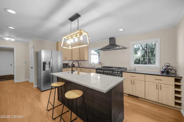 a kitchen with a stove a sink a refrigerator and furniture