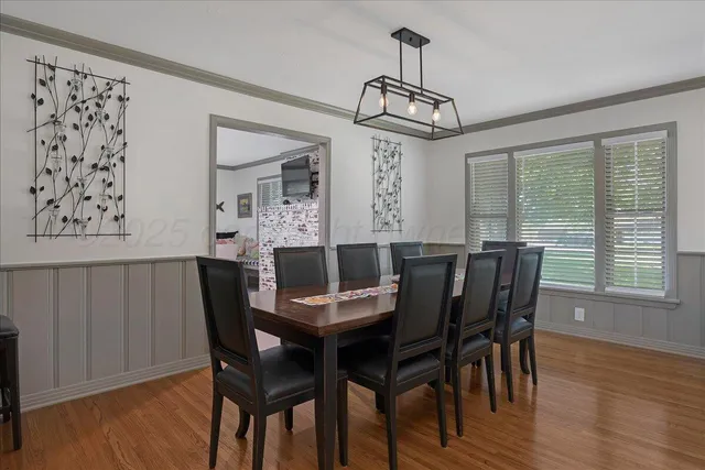 a living room with stainless steel appliances furniture a rug and a kitchen view