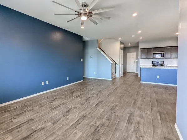 a view of a kitchen with a sink and a ceiling fan