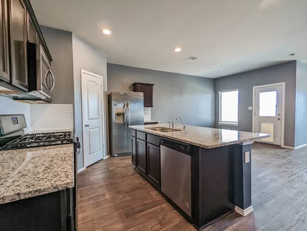 a kitchen with stainless steel appliances granite countertop a stove and a refrigerator