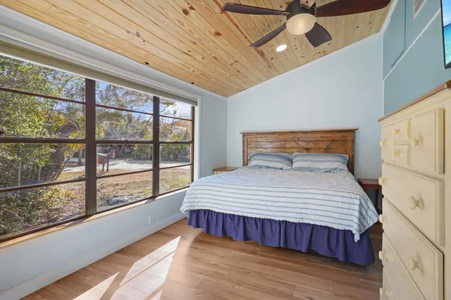 a bedroom with a large bed and a large window with outer view