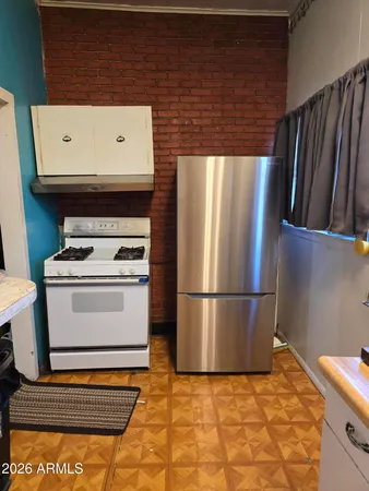 a white refrigerator freezer and a stove sitting inside of a kitchen