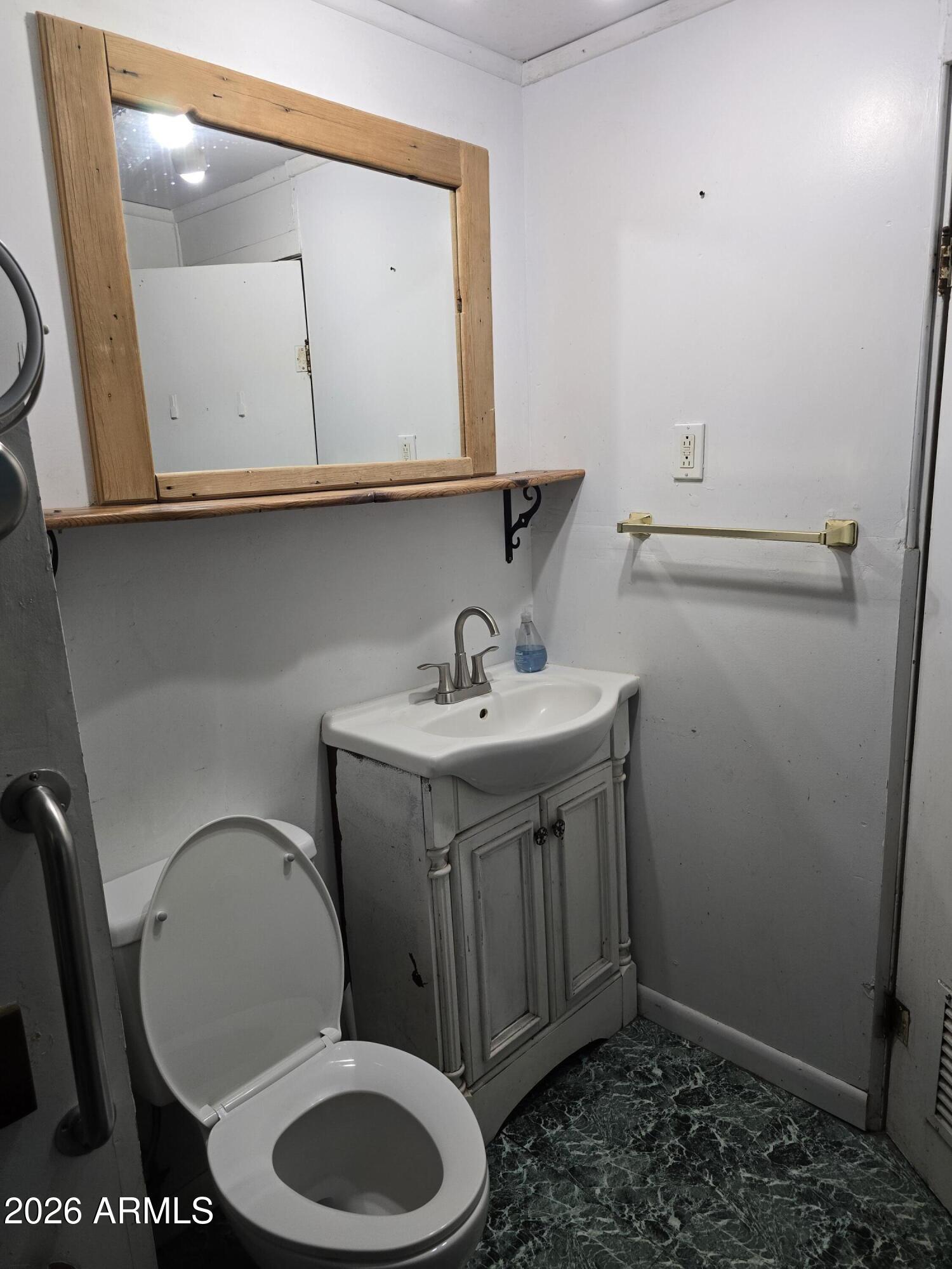 360 West Bailey Street Globe, AZ 85501 - Photo 7 of 11 a bathroom with a toilet a sink and mirror