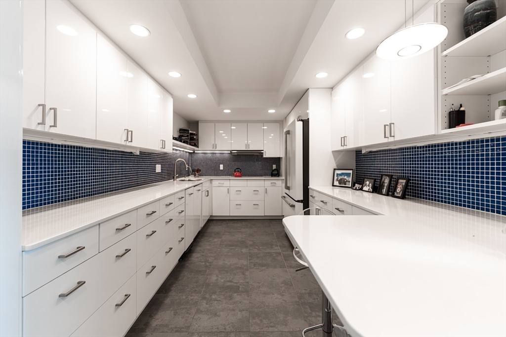 1010 Memorial Drive, Unit 6G Cambridge, MA 02138 - Photo 16 of 22 a large white kitchen with granite countertop a sink and cabinets