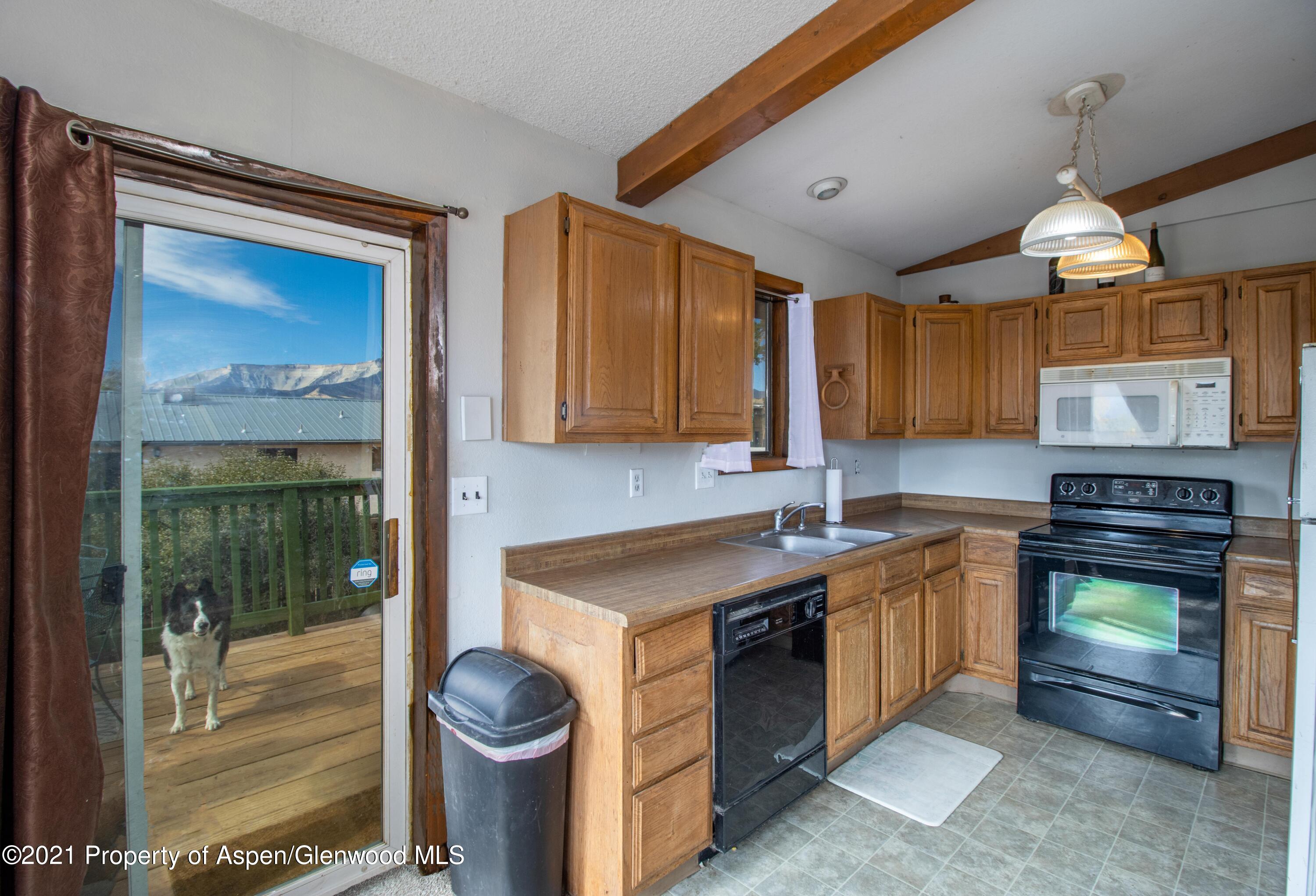 1002 Arnold Court Rifle, CO 81650 - Photo 4 of 15 a kitchen with stainless steel appliances granite countertop a stove a sink and a microwave
