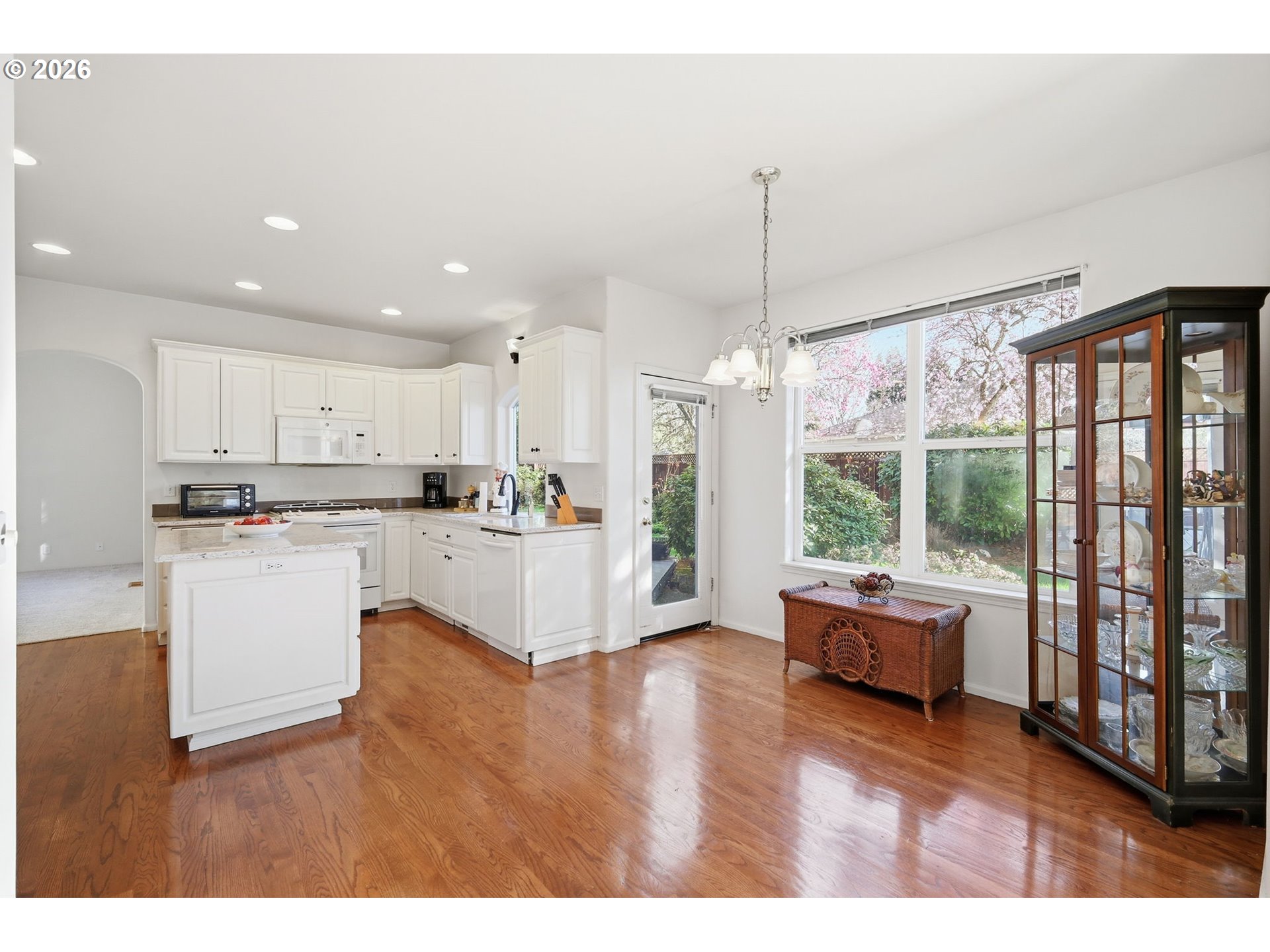 3379 South Lambert Street Eugene, OR 97405 - Photo 10 of 44 a open kitchen with granite countertop a refrigerator a stove a sink dishwasher and white cabinets with wooden floor