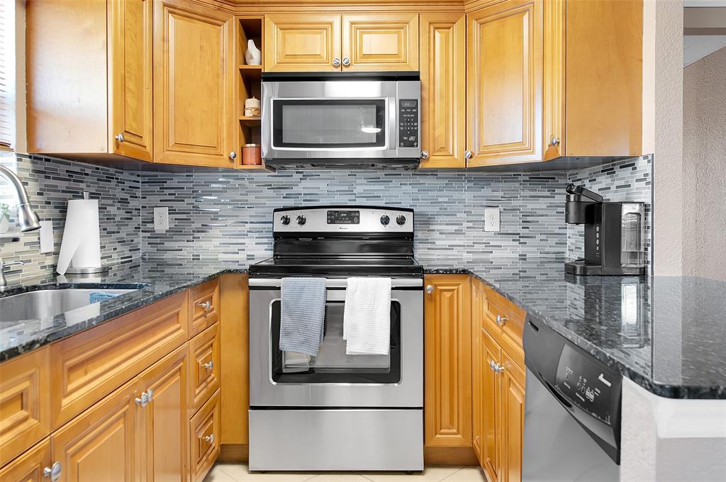 409 Brittany Drive, Unit 409 Delray Beach, FL 33446 - Photo 17 of 41 a kitchen with a stove and a microwave