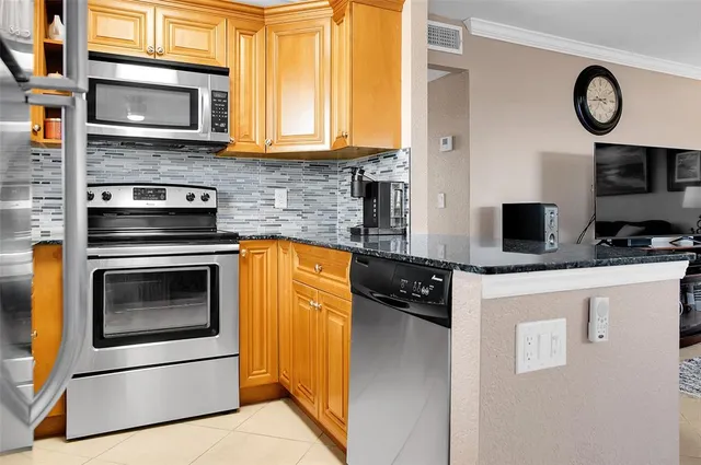 a kitchen with stainless steel appliances granite countertop a stove and a microwave