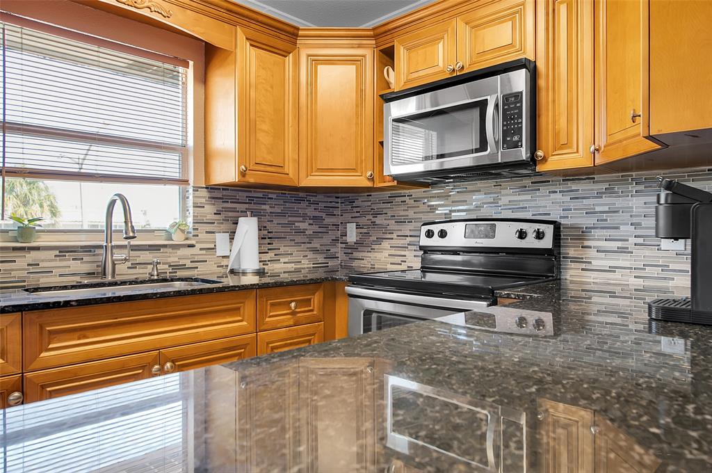 409 Brittany Drive, Unit 409 Delray Beach, FL 33446 - Photo 20 of 41 a kitchen with stainless steel appliances granite countertop a sink stove and microwave