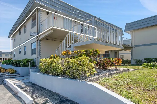 a view of a house with a yard and potted plants