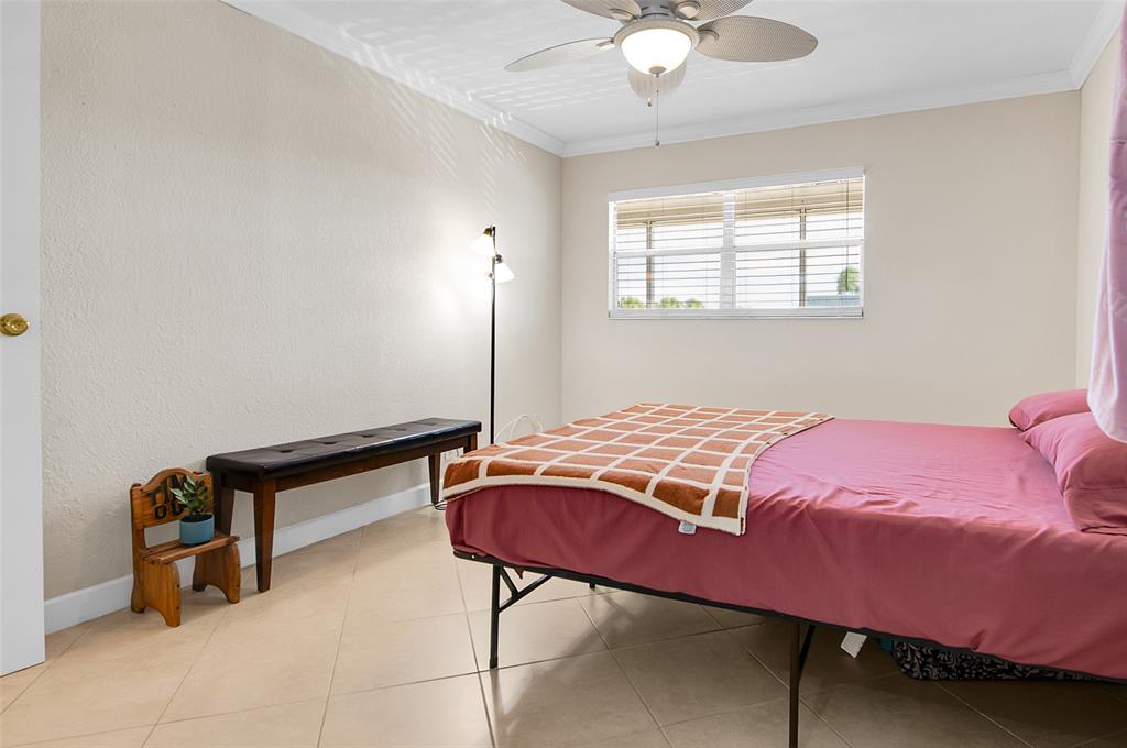 409 Brittany Drive, Unit 409 Delray Beach, FL 33446 - Photo 23 of 41 a bedroom with a bed and a chandelier