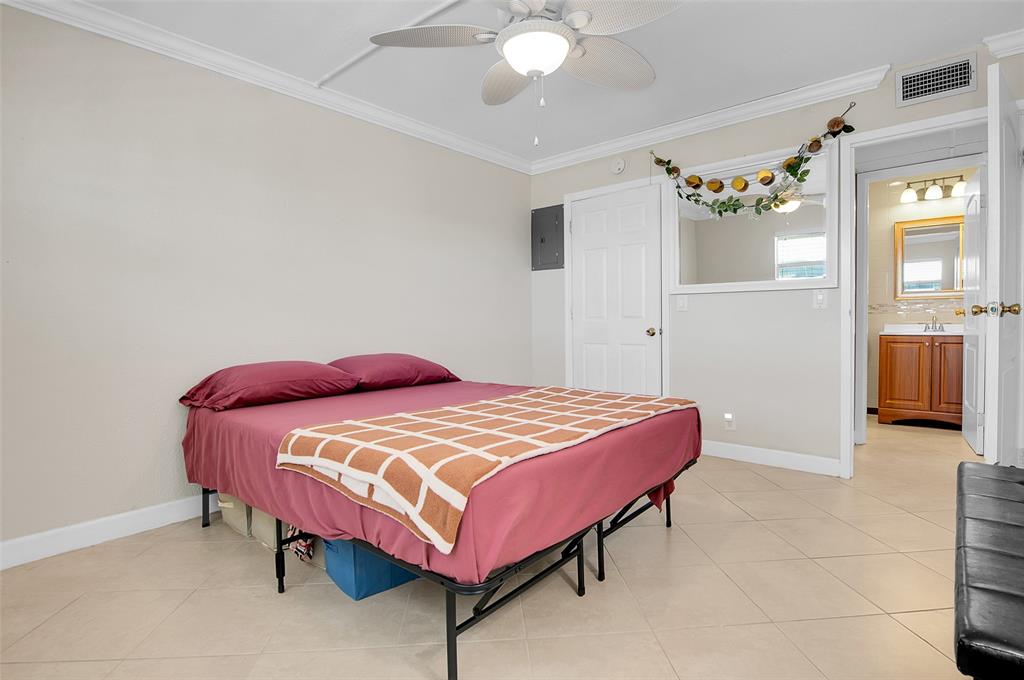 409 Brittany Drive, Unit 409 Delray Beach, FL 33446 - Photo 25 of 41 a bedroom with a bed and a chandelier