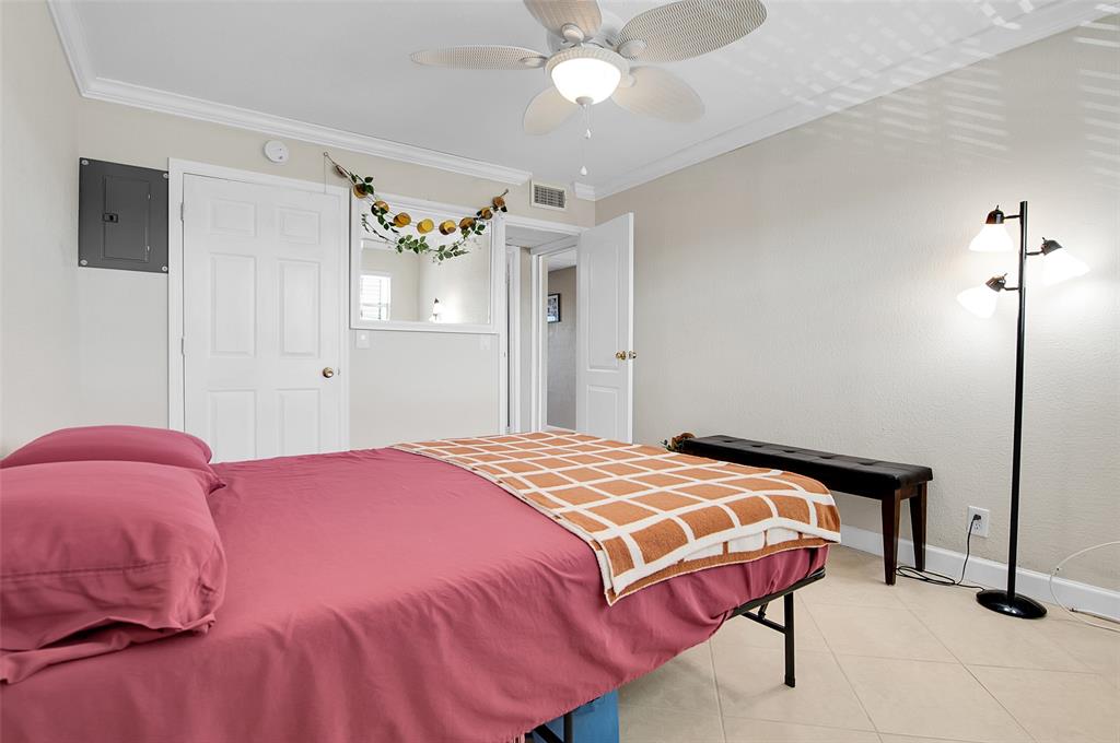 409 Brittany Drive, Unit 409 Delray Beach, FL 33446 - Photo 26 of 41 a bedroom with a bed and a chandelier