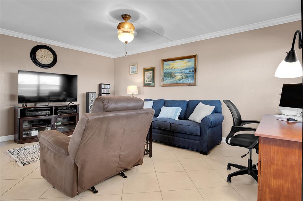 409 Brittany Drive, Unit 409 Delray Beach, FL 33446 - Photo 9 of 41 a living room with furniture and a flat screen tv