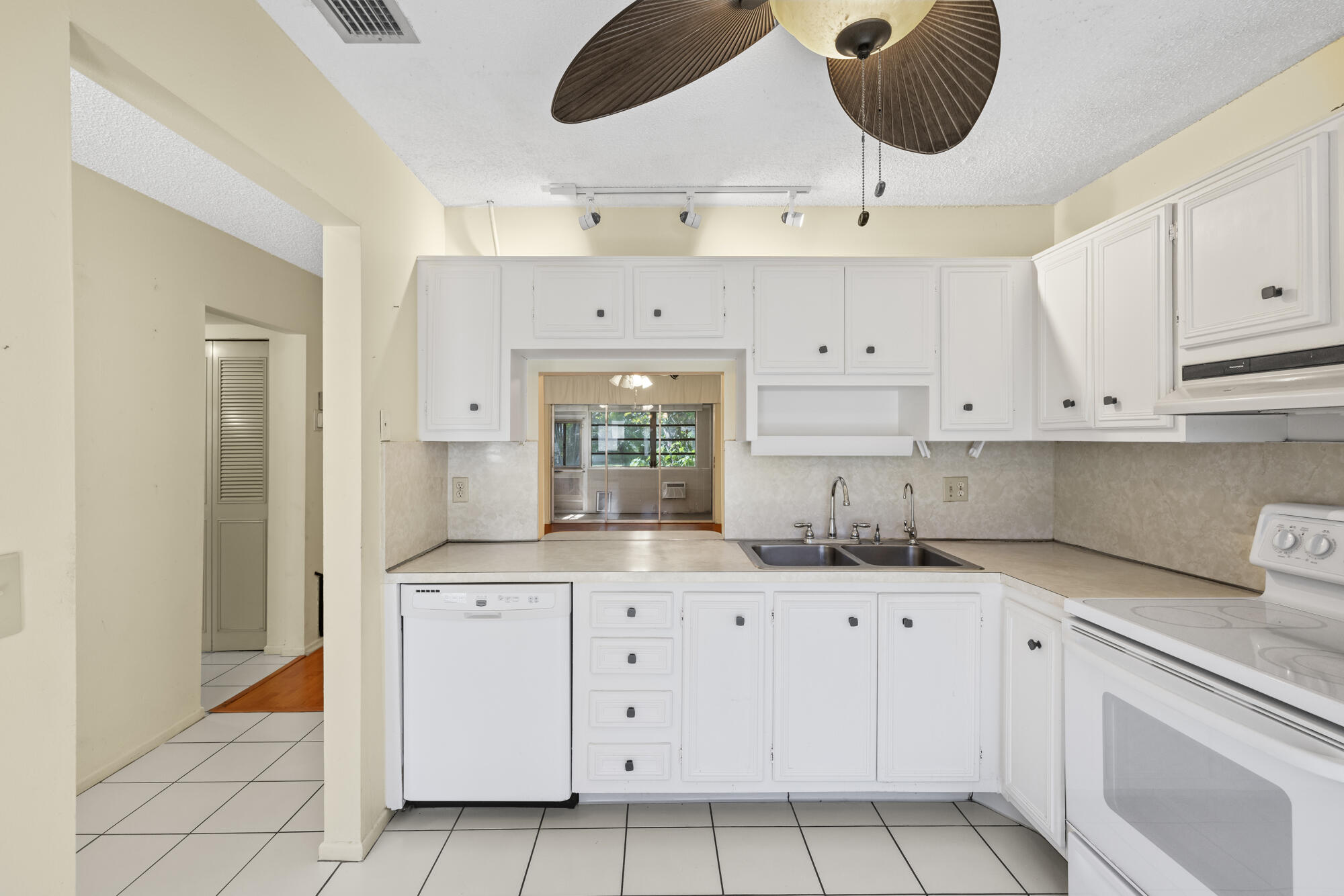 251 Down E Lane Lake Worth, FL 33467 - Photo 5 of 22 a kitchen with a sink stove and cabinets