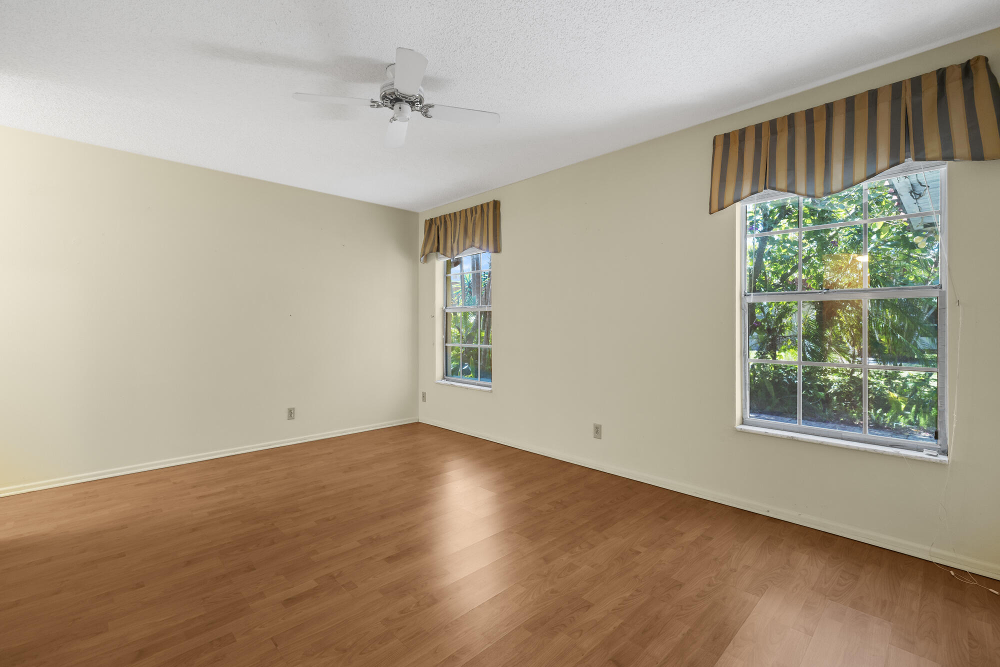 251 Down E Lane Lake Worth, FL 33467 - Photo 9 of 22 a view of an empty room with wooden floor and a window