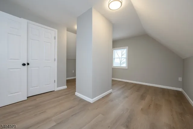 an empty room with wooden floor and window