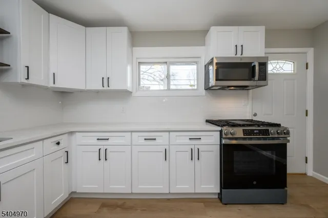 a kitchen with white cabinets and stainless steel appliances