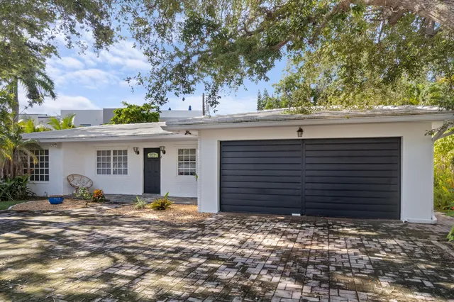 a view of a house with backyard and tree
