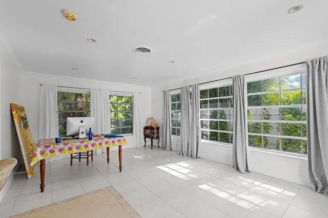 a view of an empty room with a large window and kitchen view