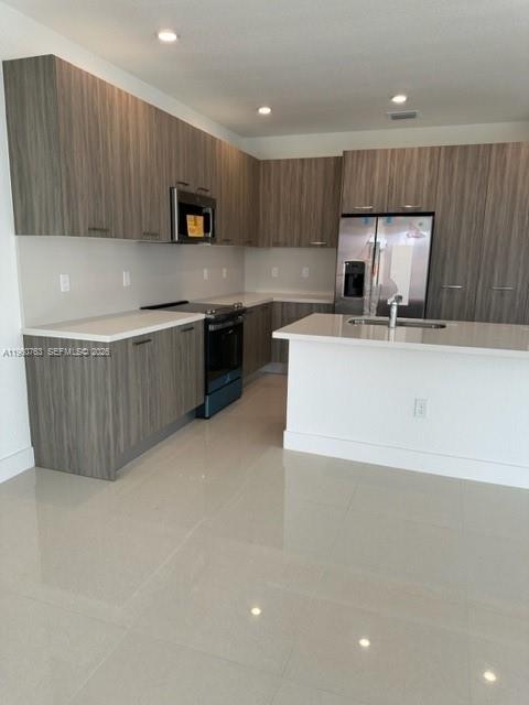 15814 Southwest 136 Way Miami, FL 33196 - Photo 5 of 33 a kitchen with kitchen island granite countertop a stove a sink a refrigerator and a oven
