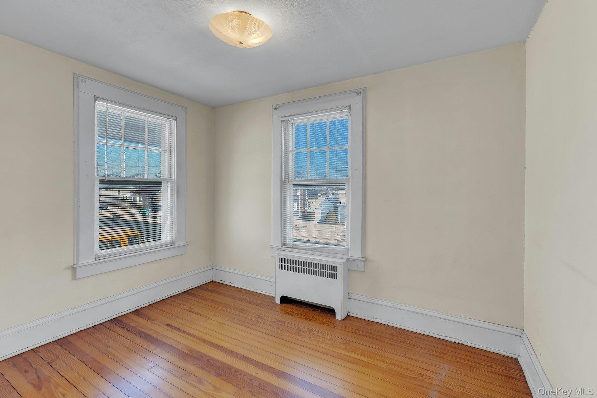 463 South 3rd Street Lindenhurst, NY 11757 - Photo 13 of 24 an empty room with wooden floor and windows