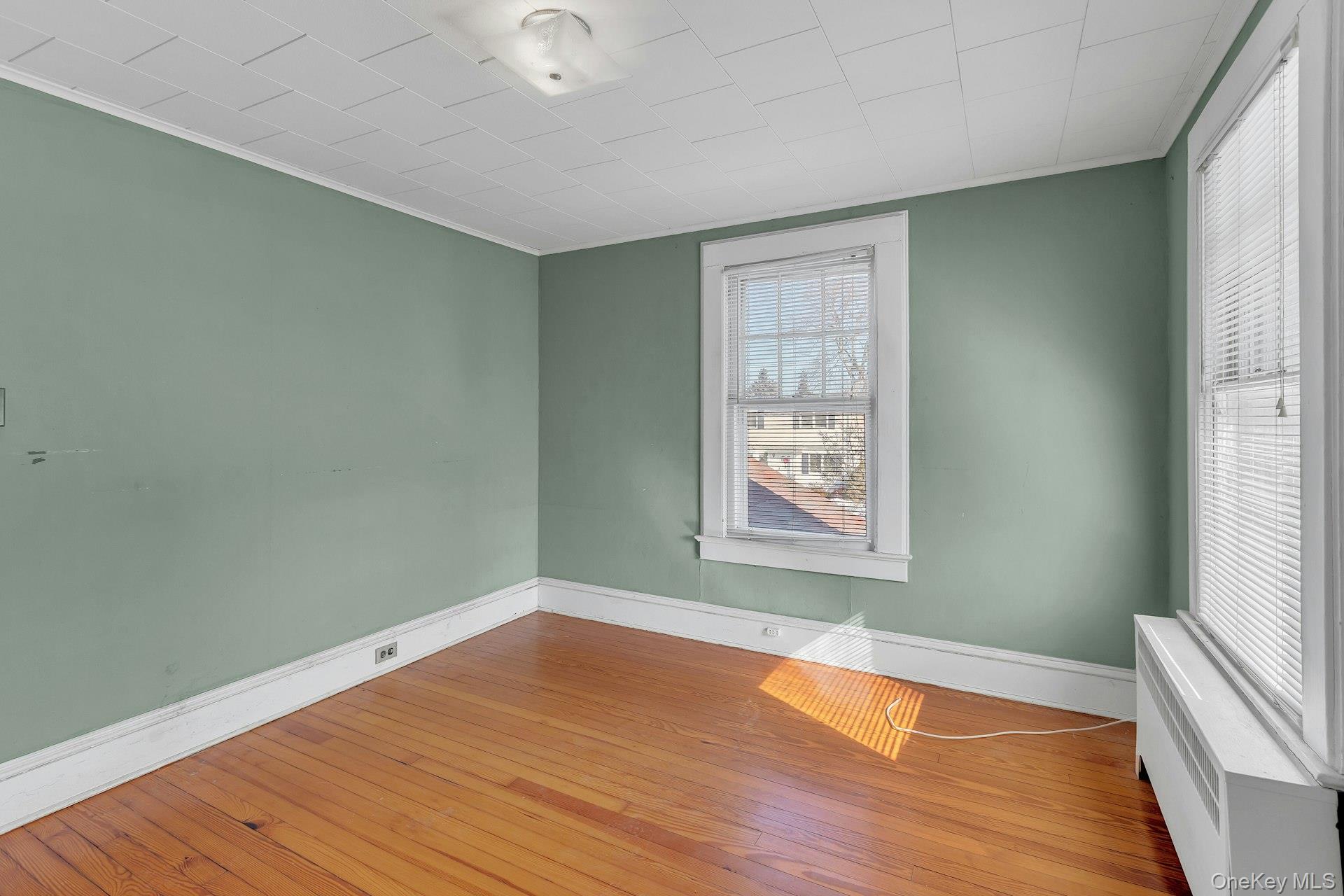463 South 3rd Street Lindenhurst, NY 11757 - Photo 14 of 24 an empty room with wooden floor and windows