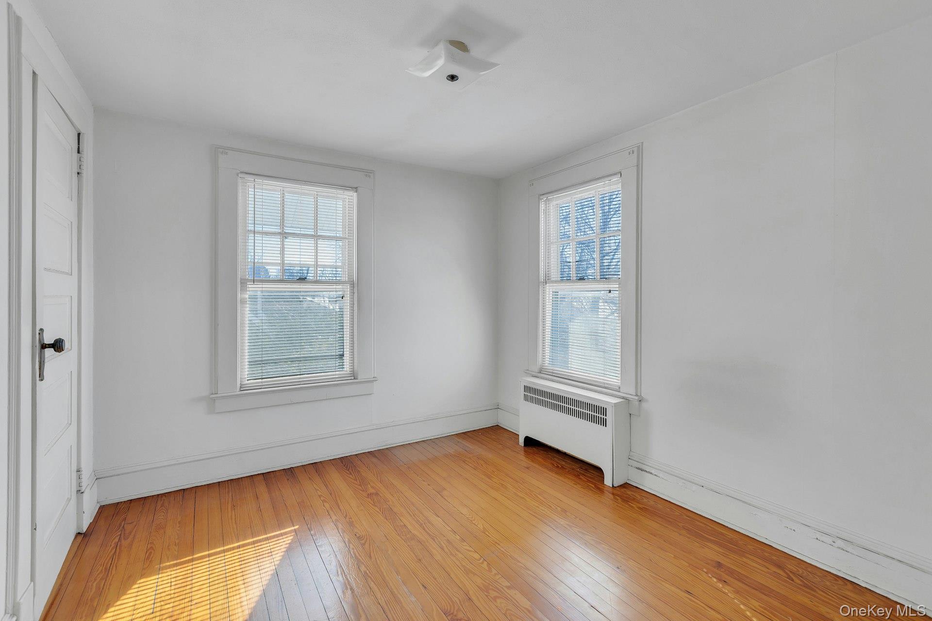 463 South 3rd Street Lindenhurst, NY 11757 - Photo 16 of 24 an empty room with wooden floor and windows
