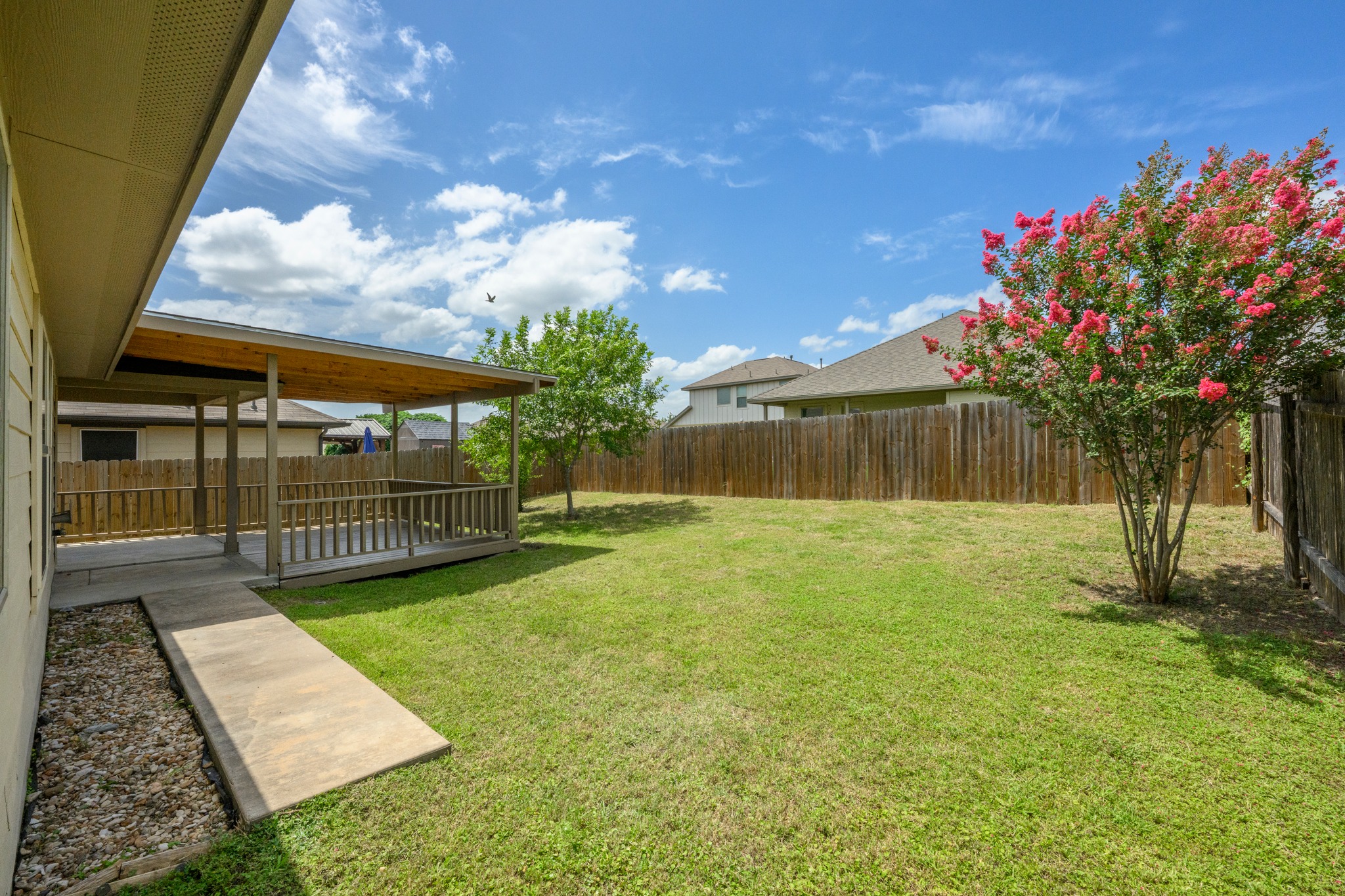 278 Noddy Road Buda, TX 78610 - Photo 15 of 17 A spacious backyard with a generous lawn and a covered deck, ideal for outdoor enjoyment.