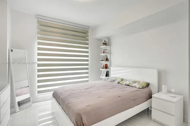 a bedroom with a bed and a large window