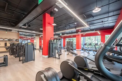 a living room with furniture gym equipment and a large window
