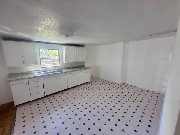 a kitchen with a sink a window and cabinets